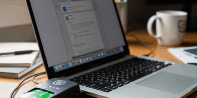 CAC card reader plugged into MacBook on desk